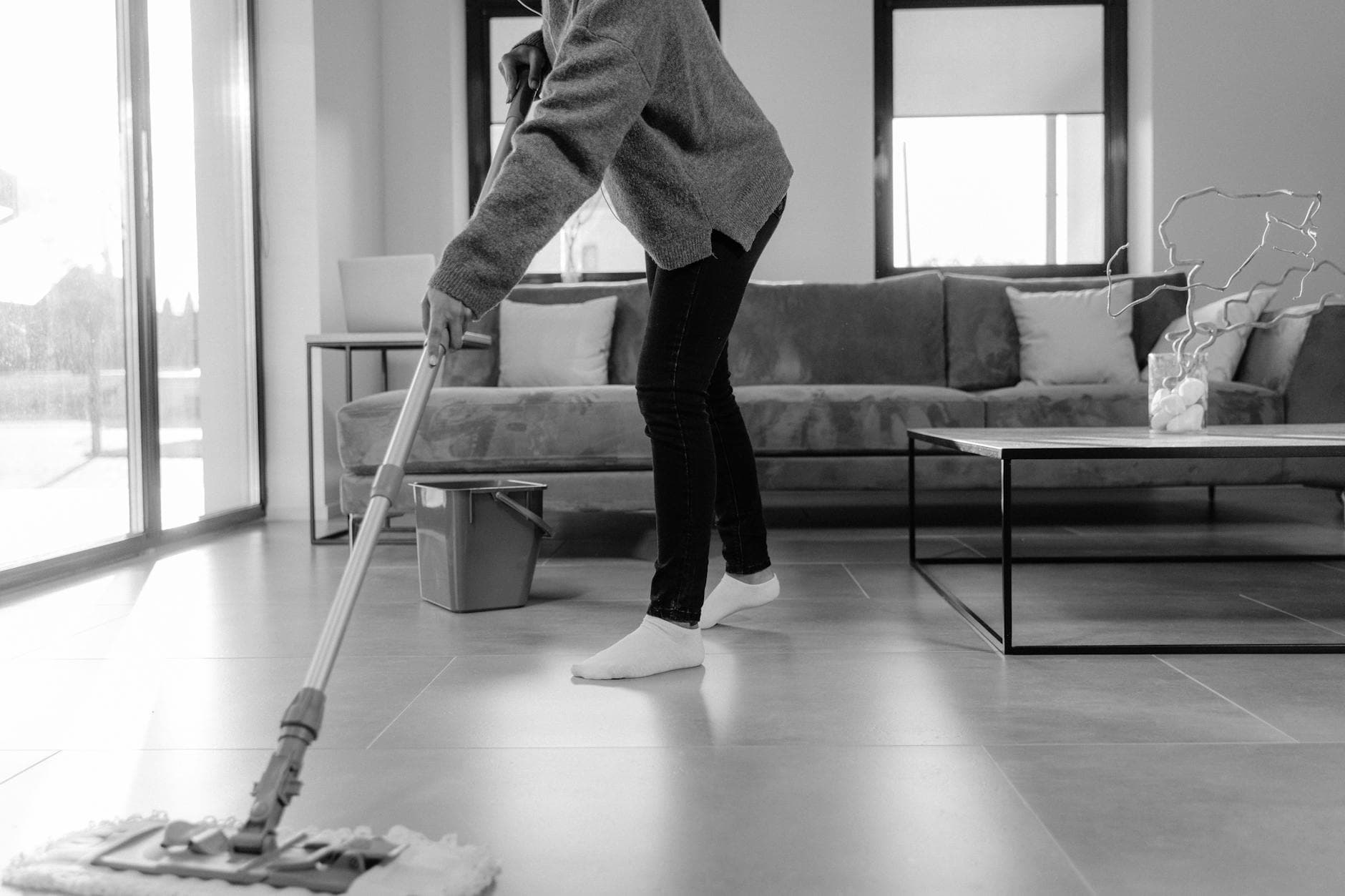 Professional NYC cleaner mopping the floor in a modern apartment living room — Monthly Cleaning in Pelham Bay, Bronx