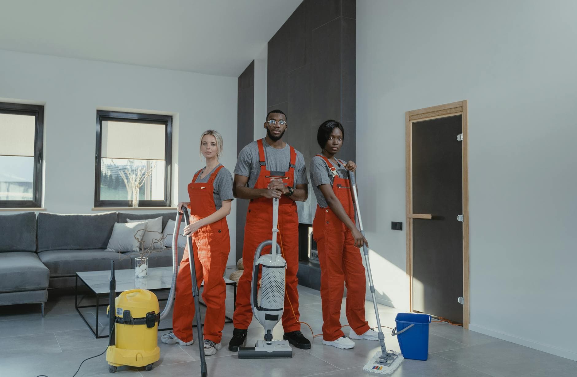 Your Business cleaning team in red uniforms ready to sanitize a modern Manhattan living room — Office Cleaning in Northport, Long Island