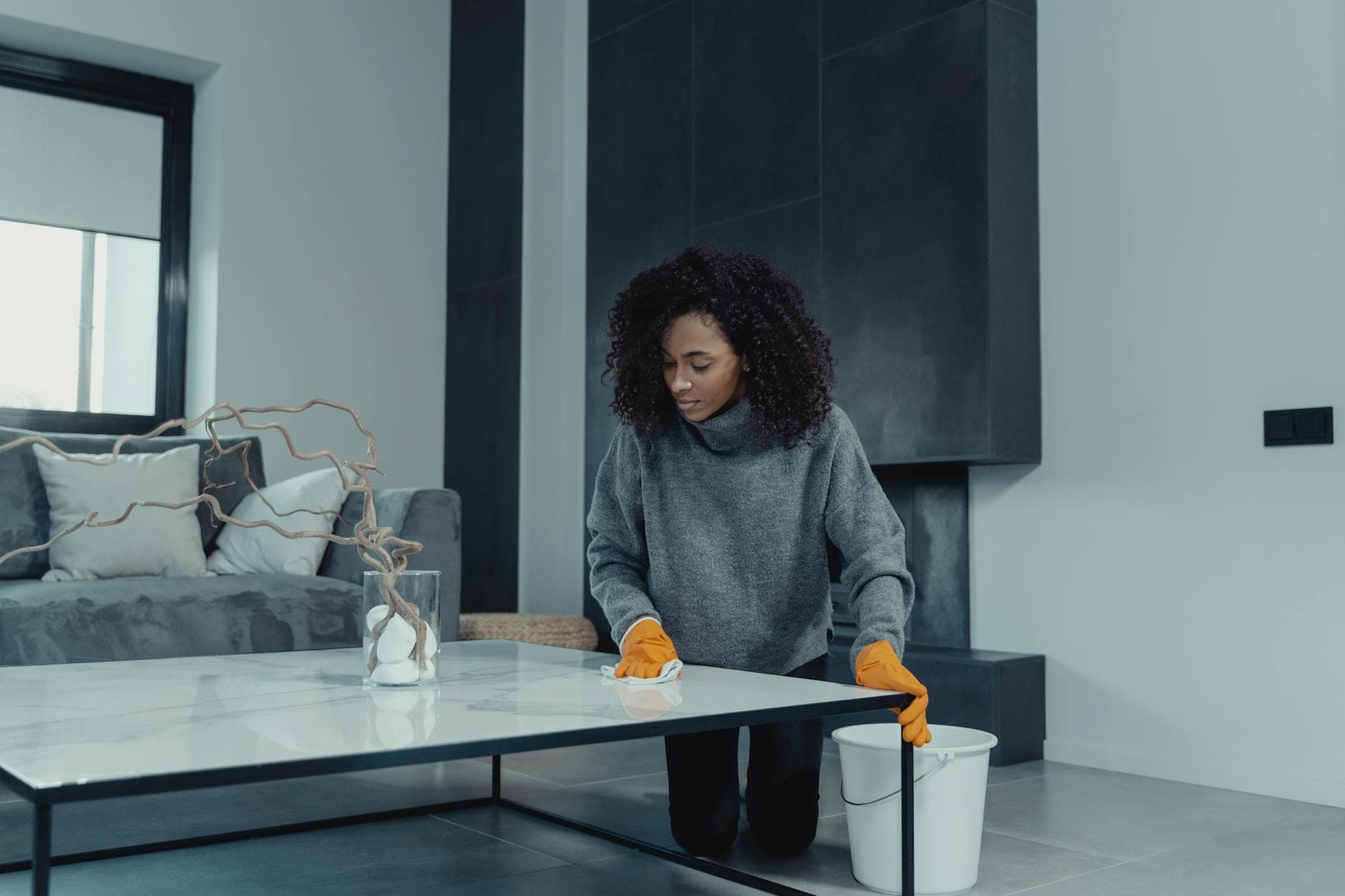 Professional house cleaner wiping a table in a contemporary New York apartment — cleaning services in Marine Park, Brooklyn