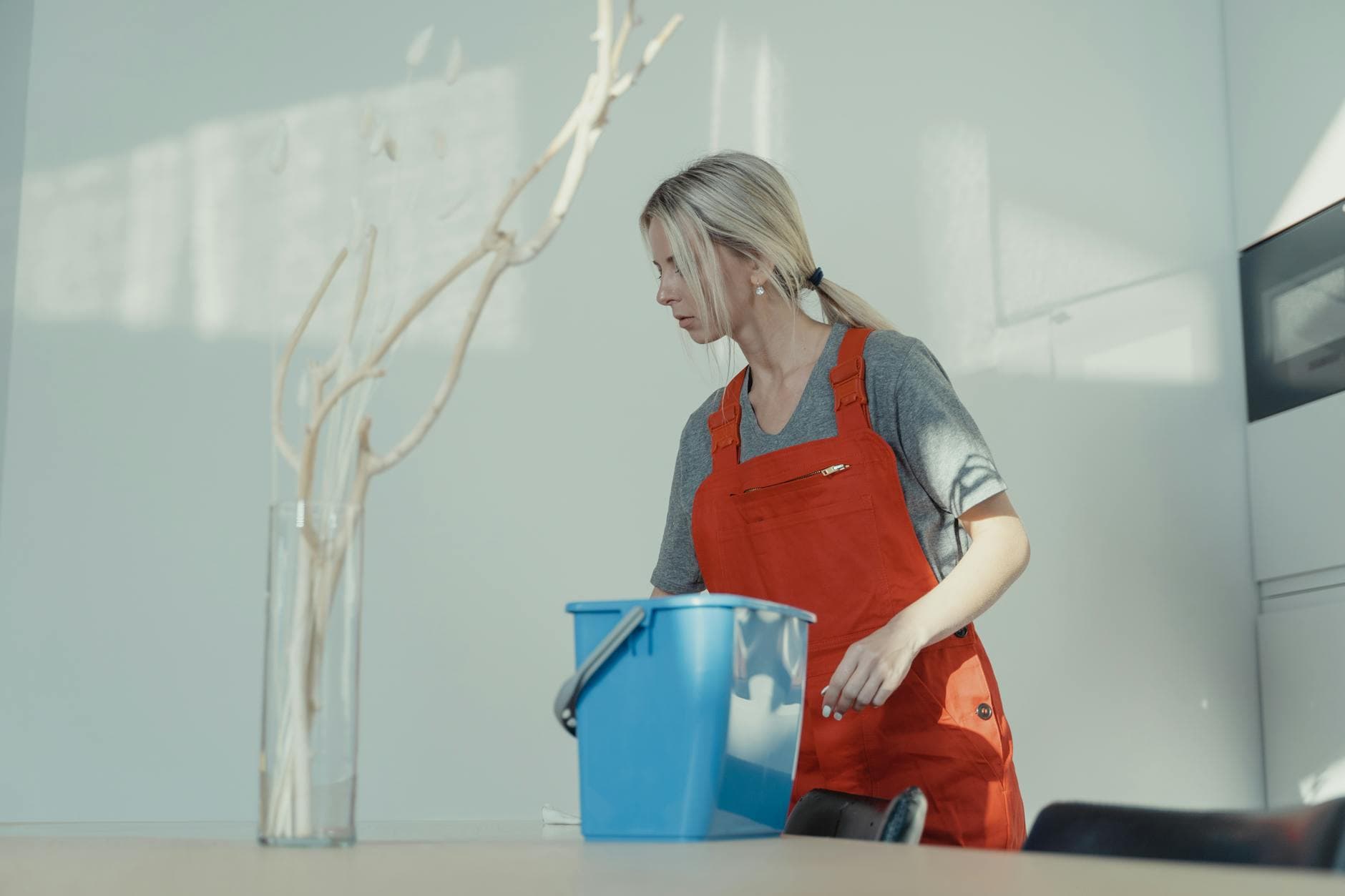 Professional cleaner from Your Business in red uniform cleaning an NYC apartment with a bucket — Office Cleaning in Flatlands, Brooklyn