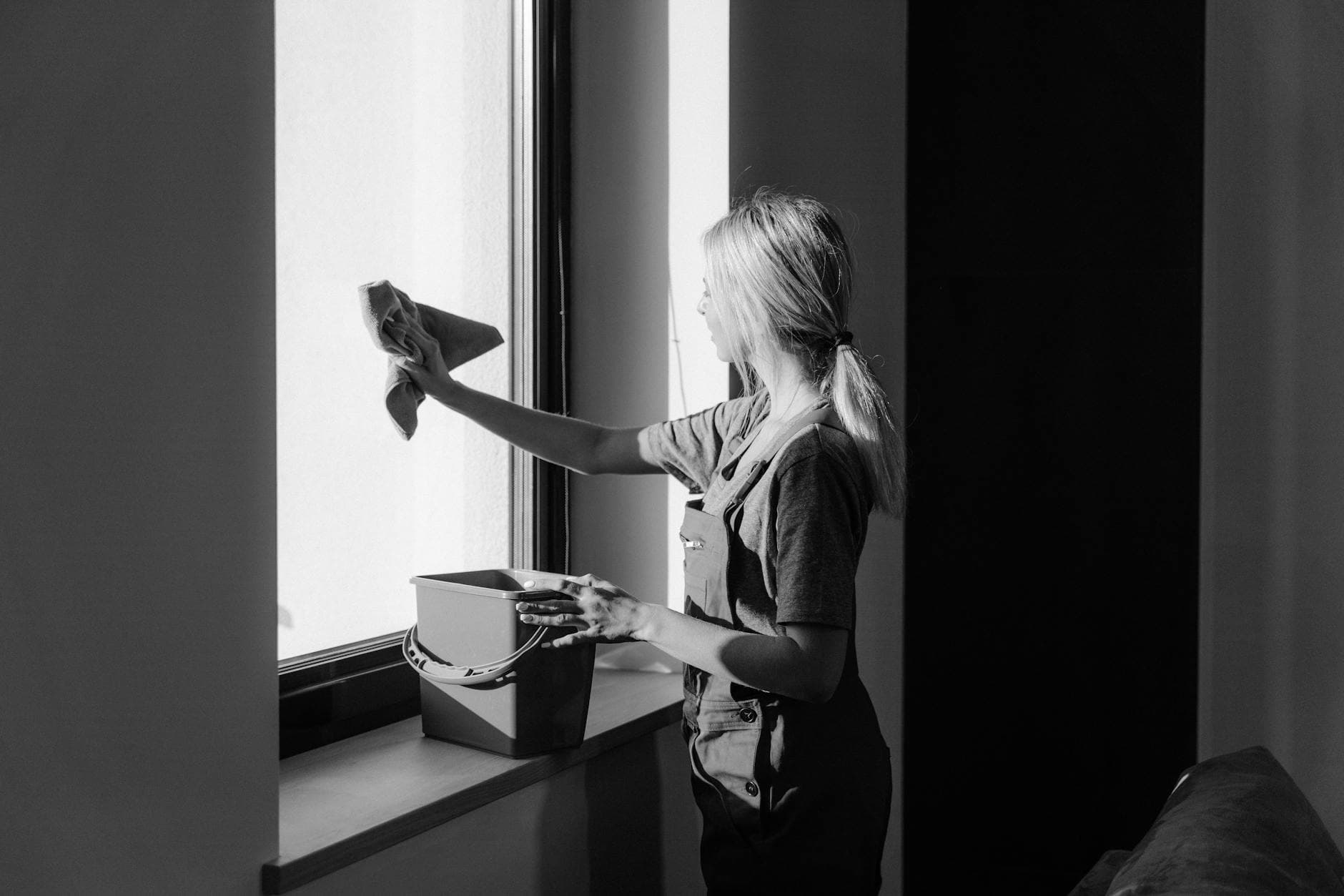 Professional window cleaning in a New York City apartment using cloth and bucket — cleaning services in Fort Hamilton, Brooklyn